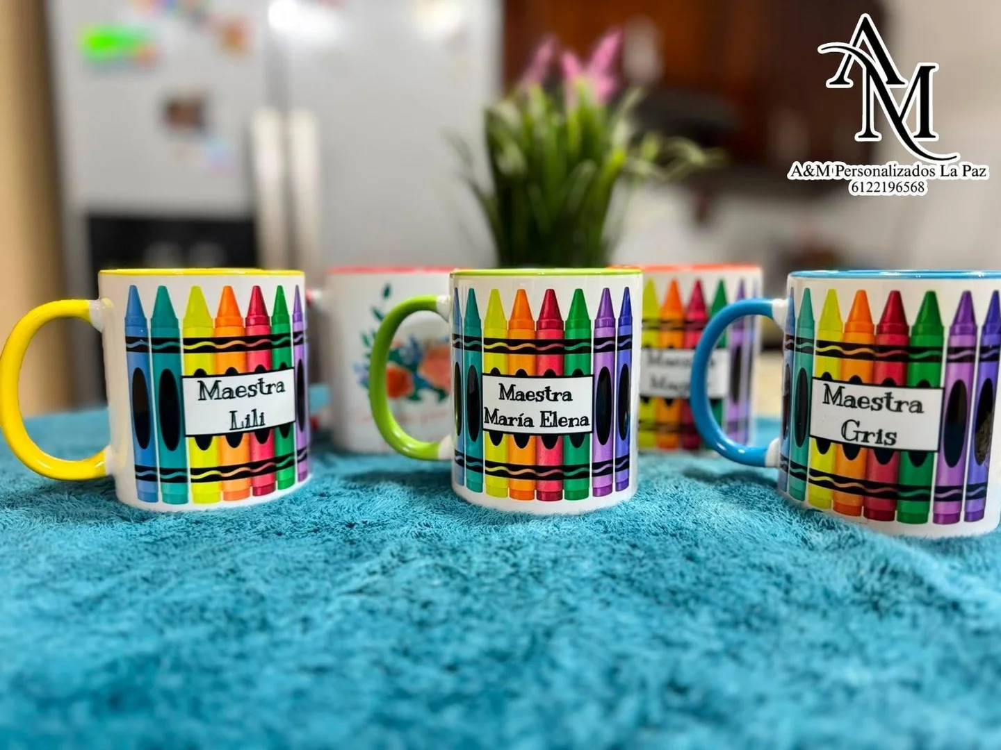 Tazas de colores con crayones y nombres de maestras